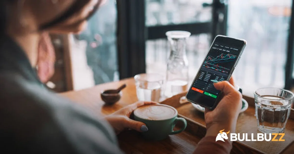 Woman checking bitcoin price charts on phone as BTC holds $84K into weekend